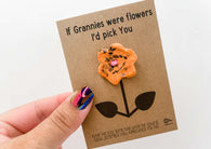a hand holding a card with a flower on it