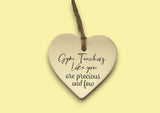a heart shaped ceramic ornament with a quote on it