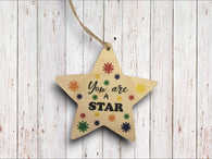 a wooden star ornament that says, you are a star
