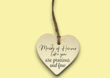 a ceramic heart hanging on a string with a message