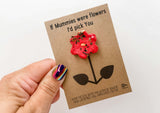 a person holding a card with a flower on it