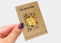 a hand holding a card with a star design on it