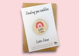 a wooden badge with the words sending you cuddles on it