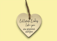 a ceramic heart hanging on a string with a message