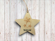 a wooden star ornament hanging on a wooden wall