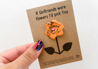 a hand holding a card with a flower on it