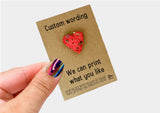 a person holding up a card with a heart on it