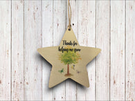 a wooden star ornament with a tree on it