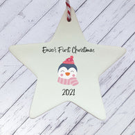 a white ceramic star ornament with a penguin on it