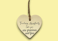 a ceramic heart hanging on a string with a message