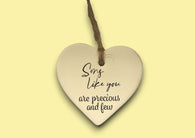 a heart shaped ceramic ornament with a saying
