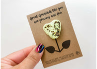 a hand holding a card with a cookie shaped like a flower