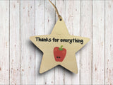 a wooden star ornament with an apple on it